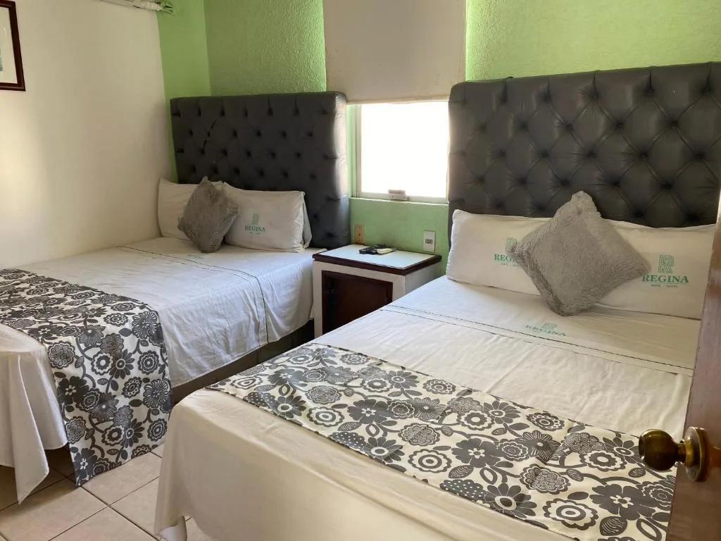 Hotel room with two beds and green accents